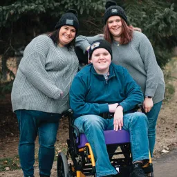 Family photo of a mom and her teenagers outside. 