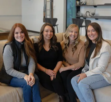 Four coworkers sitting together as a team on a couch.