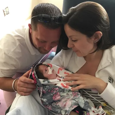 Parents kissing their newborn baby on the head