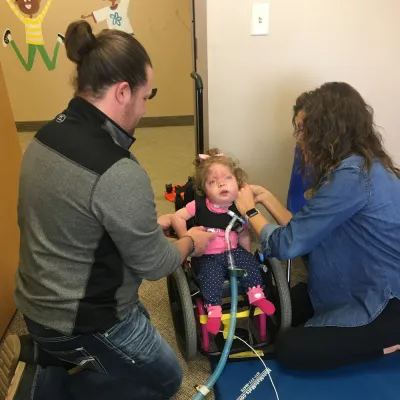 Little girl in wheelchair getting physical therapy