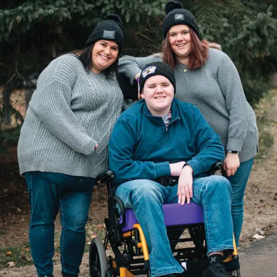 Family photo of a mom and her teenagers outside. 