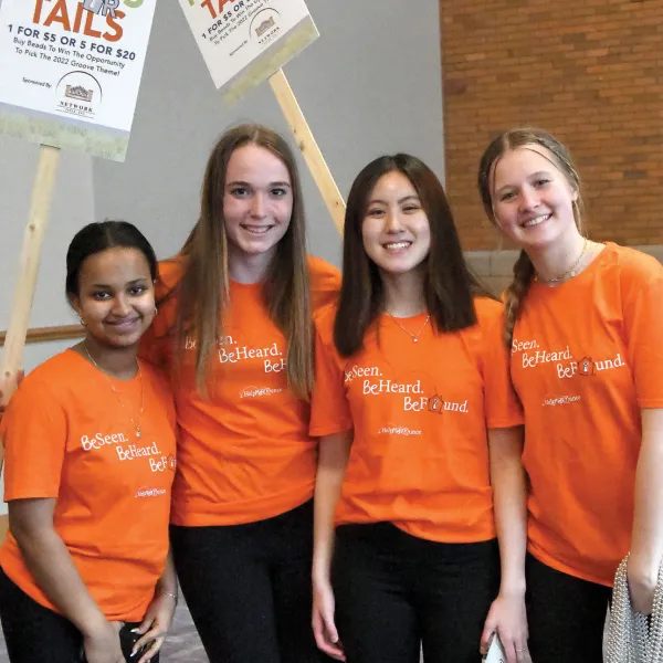 volunteers in orange shirts at event smiling