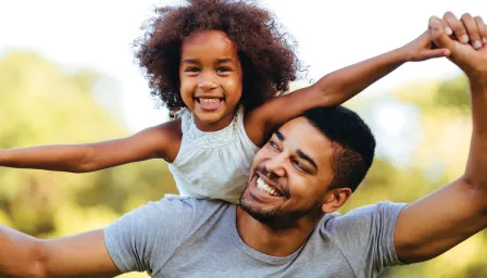 Dad with daughter on back smiling