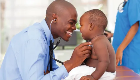 Doctor holding stethoscope to baby's chest