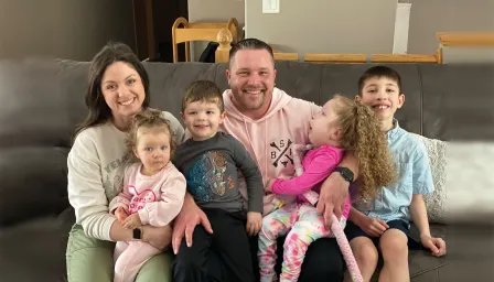 Photo of happy family inside their house with parents and four children.