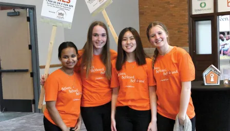 volunteers in orange shirts at event smiling