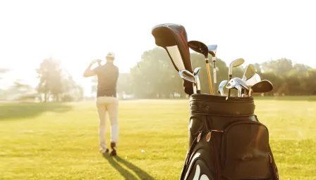 Man golfing with golf bag behind him