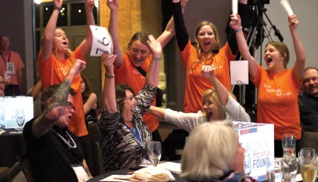 Volunteers celebrating with attendees at a non-profit gala