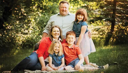 Family photo of parents with three children outside